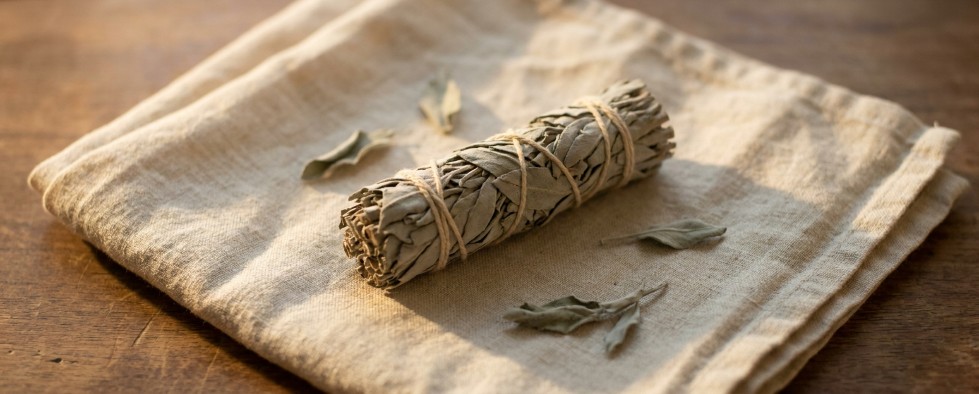Witte salie smudge stick op linnen aardetinten zachte daglicht